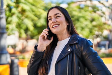 Young woman smiling confident talking on the smartphone at park