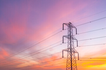Low angle view of electricity pylon and wires carrying high voltage electricity with dramatic...