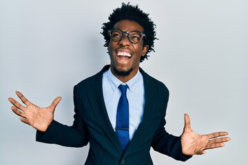 Young african american man wearing business suit crazy and mad shouting and yelling with aggressive expression and arms raised. frustration concept.