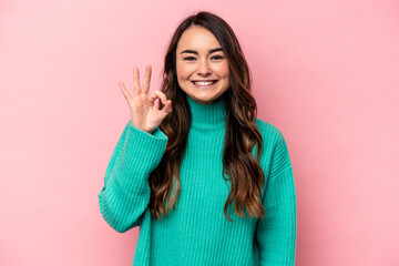 Young caucasian woman isolated on pink background cheerful and confident showing ok gesture.