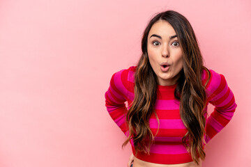 Young caucasian woman isolated on pink background being shocked because of something she has seen.