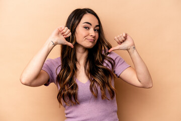 Fototapeta premium Young caucasian woman isolated on beige background feels proud and self confident, example to follow.