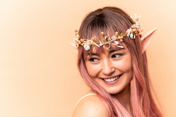 Young elf woman with pink hair isolated on beige background