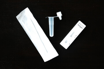 Selective focus of nasal swab test kit set on dark background table.