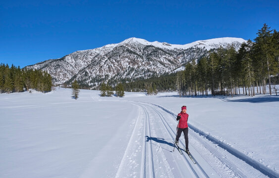 Senior woman skiing on snow at vacation