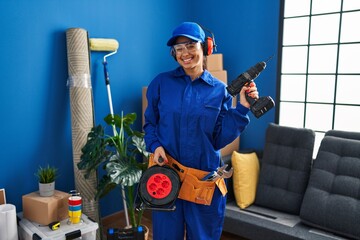Young hispanic technician working at home renovation winking looking at the camera with sexy...