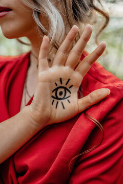 Young woman showing eye sign tattoo on her hand