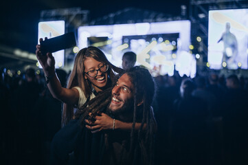 Couple taking selfie with a smartphone on a music festival