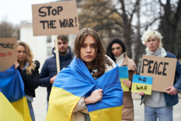 Group of young caucasian people manifesting against war in Ukraine