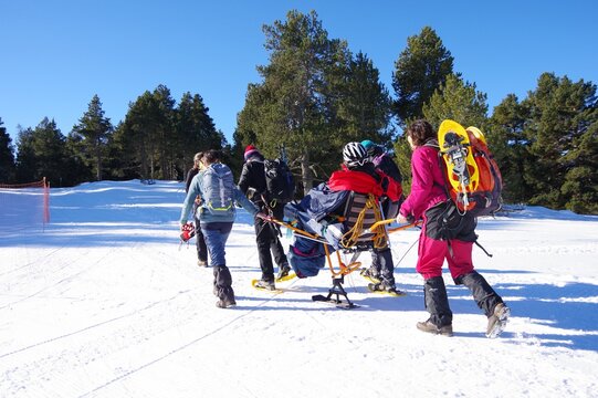 Randonn&eacute;e solidaire avec handicap&eacute;s en fauteuil roulant et aveugles sur la neige avec des raquettes et des patins en montagne en hiver