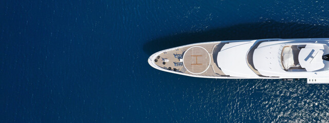 Aerial drone ultra wide top down photo of large yacht with wooden deck anchored in Aegean island...
