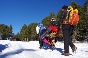 Randonnée solidaire avec handicapés en fauteuil roulant et aveugles sur la neige avec des raquettes et des patins en montagne en hiver