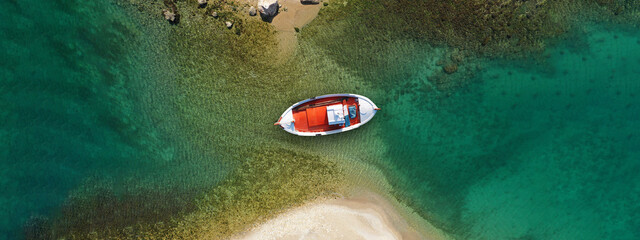 Fototapeta na wymiar Aerial drone ultra wide top view photo of traditional red fishing boat anchored in exotic Ionian destination island with emerald sea, Greece