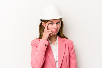 Young architect English woman with helmet isolated on white background pointing temple with finger, thinking, focused on a task.
