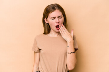 Young English woman isolated on beige background yawning showing a tired gesture covering mouth with hand.