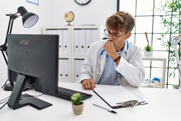 Young caucasian doctor man working at the clinic feeling unwell and coughing as symptom for cold or bronchitis. health care concept.