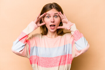 Young English woman isolated on beige background receiving a pleasant surprise, excited and raising hands.