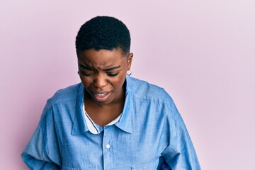 Young african american woman wearing casual clothes with hand on stomach because nausea, painful disease feeling unwell. ache concept.