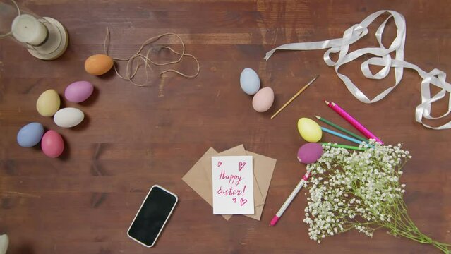 Top view of a table with items to create a composition for Easter. Women's hands arrange objects on the table. Church holiday-Easter
