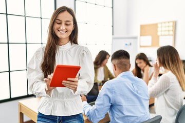 Group of business workers working sitting on the table. Woman smiling happy and using touchpad standing at the office.