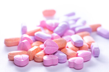 Obraz na płótnie Canvas Closeup shot of a pile of colorful pills on white background.