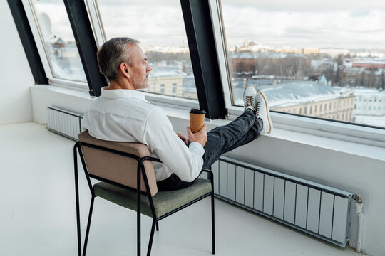 Businessman with disposable coffee cup at work place