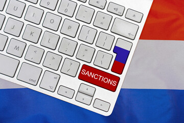 White computer keyboard with button of flag Russia and red button with word of sanctions on...