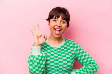 Young hispanic woman isolated on pink background cheerful and confident showing ok gesture.