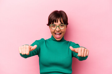 Young hispanic woman isolated on pink background raising both thumbs up, smiling and confident.