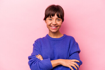 Fototapeta premium Young hispanic woman isolated on pink background who feels confident, crossing arms with determination.