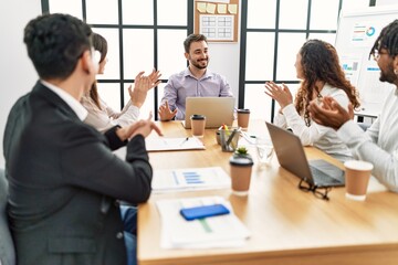 Group of business workers smiling and clapping to partner at the office.