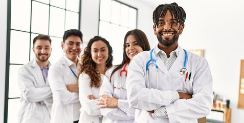 Group of young doctor smiling happy standing with arms crossed gesture at the clinic office.
