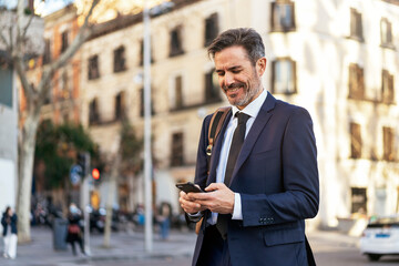 Businessman browsing smartphone in city
