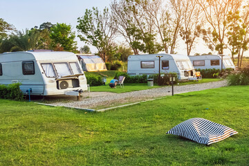 Pillow or mattress for relax on green grass with Cozy retro travel trailer Caravan near riverside...