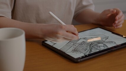 Girl artist draws on the tablet a project of buildings for a casual game