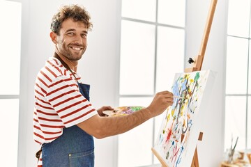 Young hispanic man smiling confident drawing at art studio