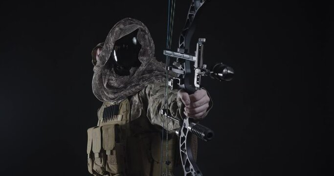 An archer in military uniform takes aim and makes a shot. The concept of modern warfare is the silent killer.