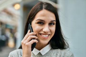 Young hispanic woman smiling happy talking on the smartphone at the city.