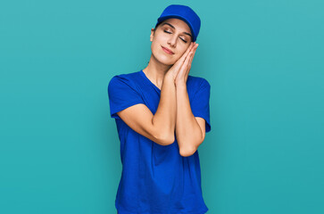 Young hispanic girl wearing delivery courier uniform sleeping tired dreaming and posing with hands together while smiling with closed eyes.