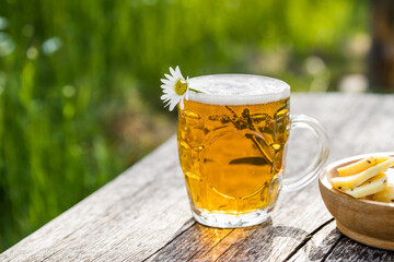 Glass of light beer with cheese and chamomile
