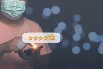 Customers satisfaction, give service ranking on a digital online application for best product and service. A man using smartphones sends messages five yellow stars for review products satisfaction.