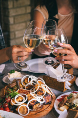 Dinner at the restaurant, wine glasses, a plate with barbecue, sauce and salad