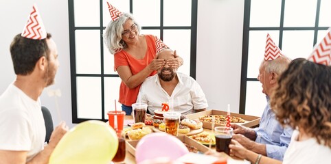 Group of middle age friends smiling happy celebrate birthday at home.