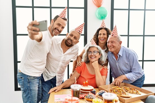 Group of middle age friends celebrate birthday make selfie by the smartphone at home.