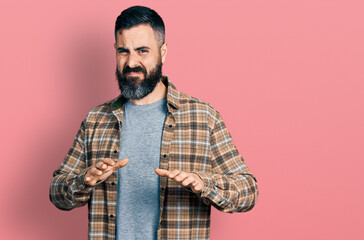 Hispanic man with beard wearing casual shirt disgusted expression, displeased and fearful doing disgust face because aversion reaction. with hands raised