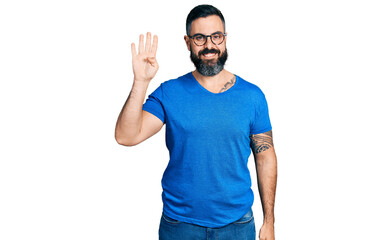Hispanic man with beard wearing casual t shirt and glasses showing and pointing up with fingers number four while smiling confident and happy.