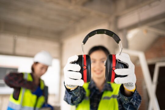 Pretty Asian Engineer,foreman Campaign to wear soundproofing equipment.Recommendations for wearing ear muffs.
Work safely with noise reduction.
a young woman using an electric screwdriver safely.