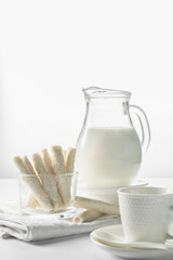 Jug with milk and coconut flake sweet waffle rolls