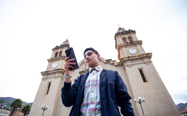 Joven emocionado revisando su celular
