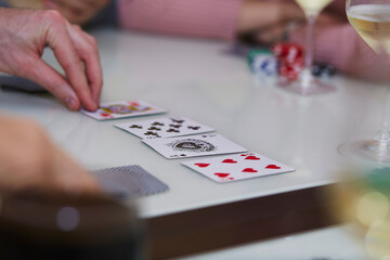 Man's hand in a poker game. Chips, cards, glass of champagne on the table with reflection. Lifestyle photography. Poker club.